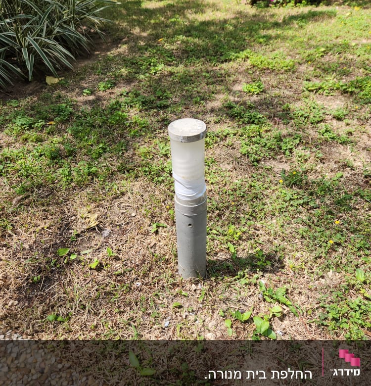 עמוד תאורה קטן בגינה על דשא